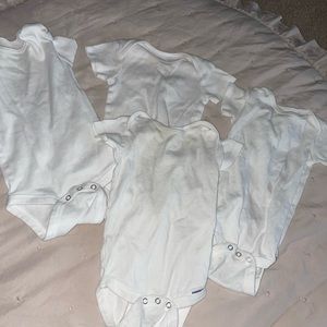 Four 3-6 month white onesies